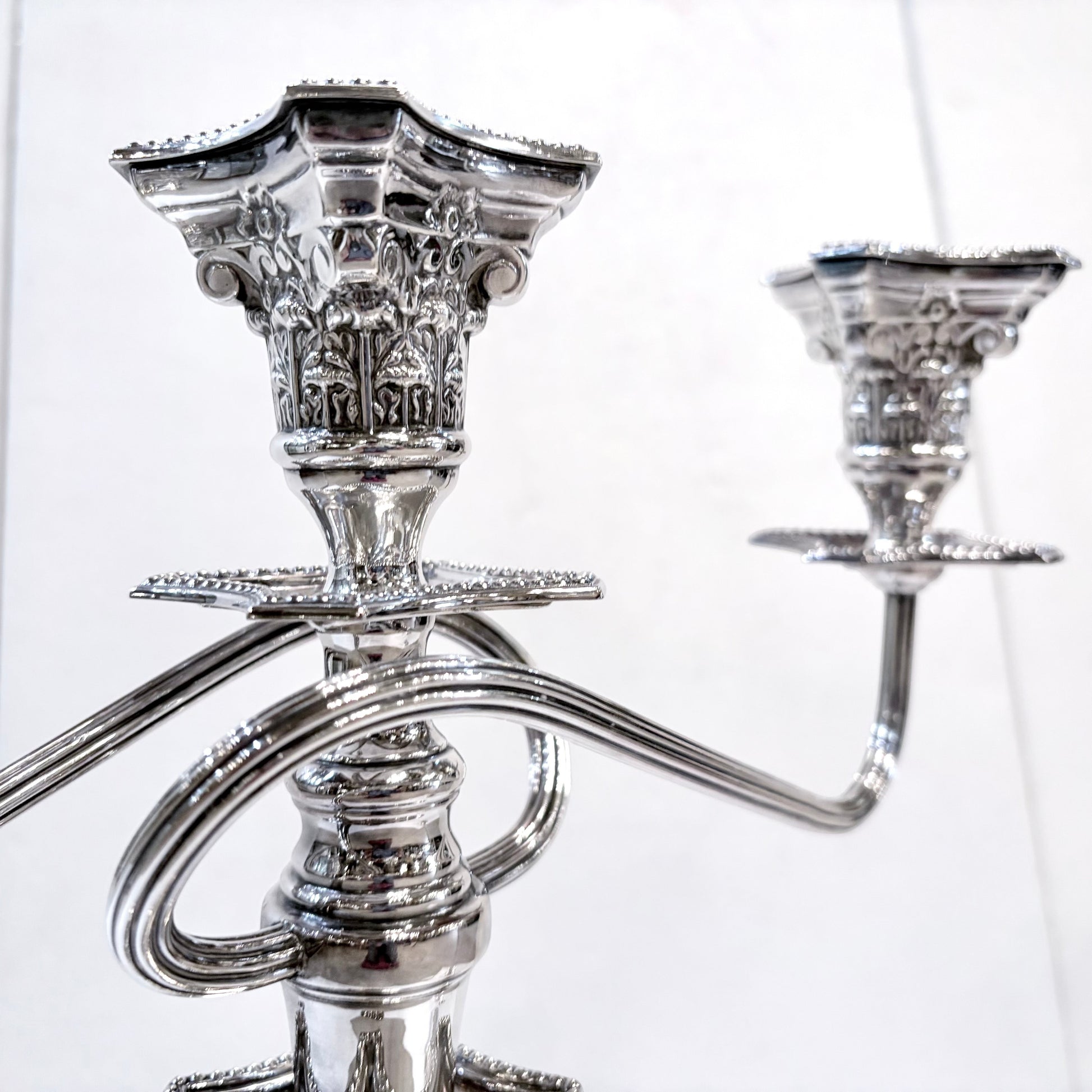 KLS Vaults pair of George III style sterling silver three-light candelabra with ornate Corinthian column design.