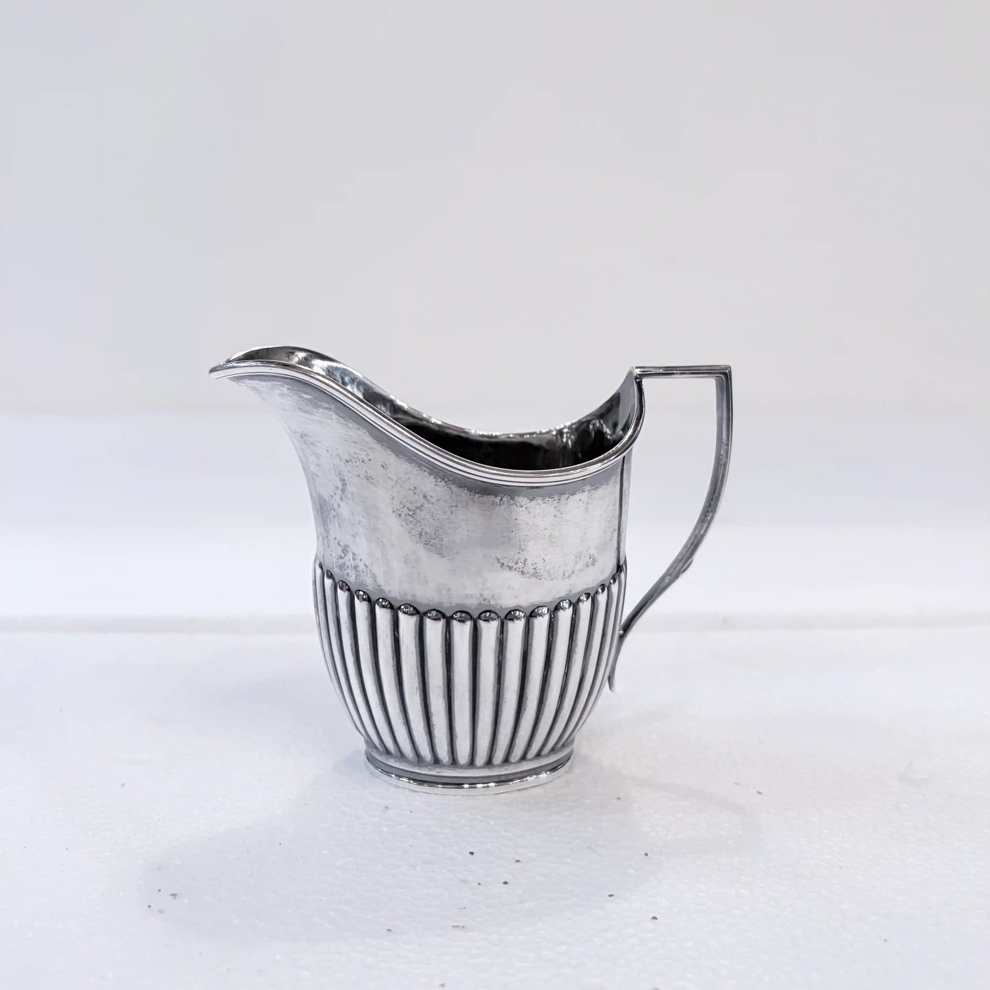 KLS Vaults Edwardian sterling silver cream jug with gadrooned base and bead-and-reel border, Sheffield 1916.