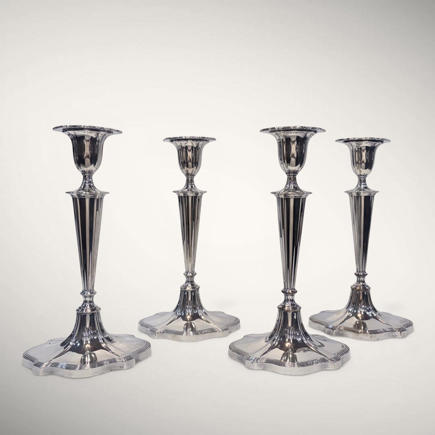 KLS Vaults set of four George V sterling silver fluted candlesticks with hexafoil bases, Sheffield 1926.