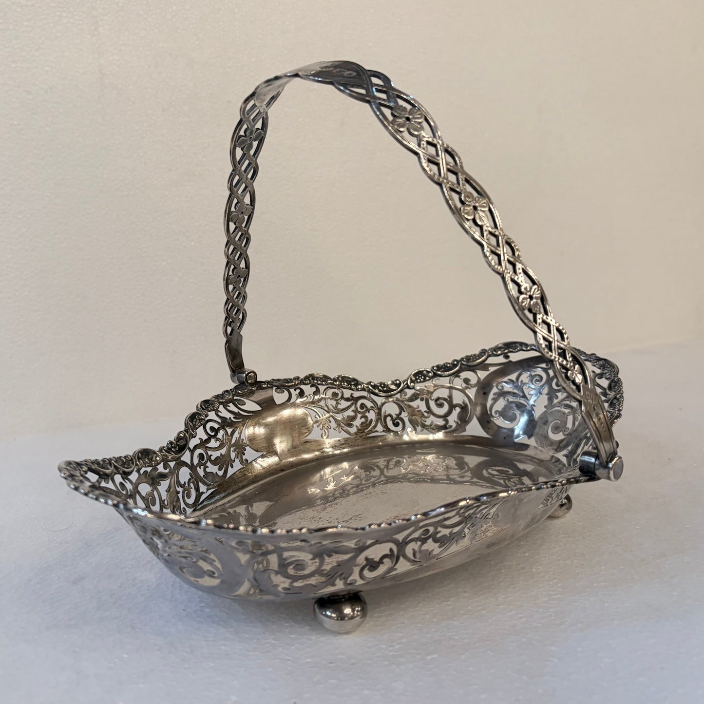 KLS Vaults Edwardian sterling silver fruit basket with intricate pierced foliate rim and lattice swing handle.