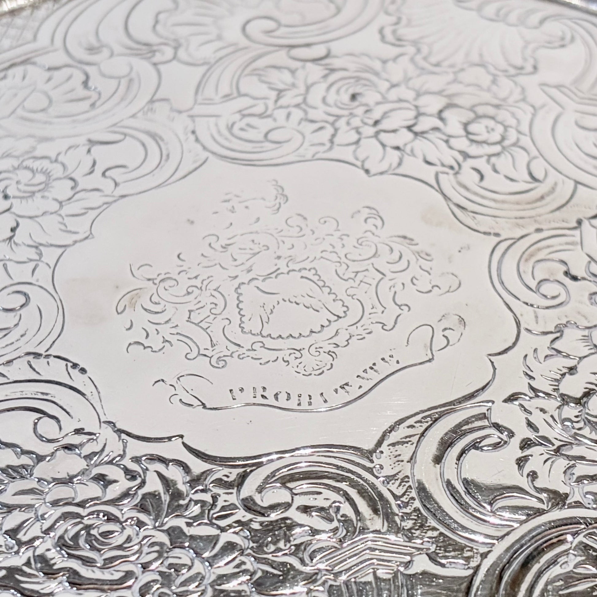 KLS Vaults 1831 William IV sterling silver salver featuring intricate chased floral motifs and a central armorial crest.
