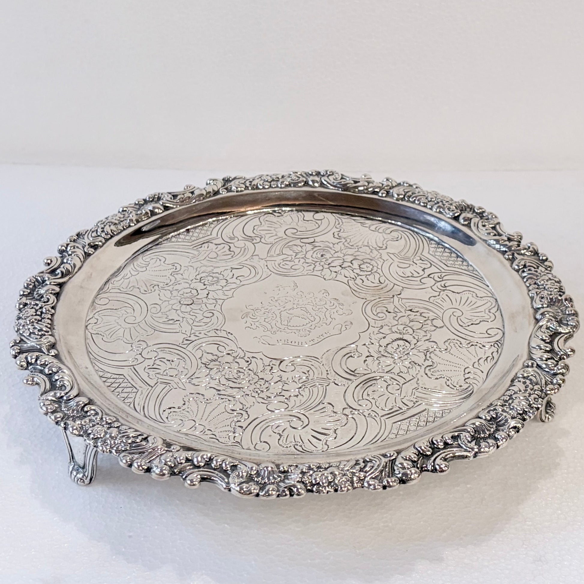 KLS Vaults 1831 William IV sterling silver salver with ornate acanthus leaf border and central armorial crest.