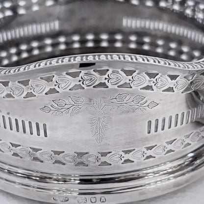 KLS Vaults pair of 1936 sterling silver wine coasters with intricate pierced fretwork and engraved foliate motifs.