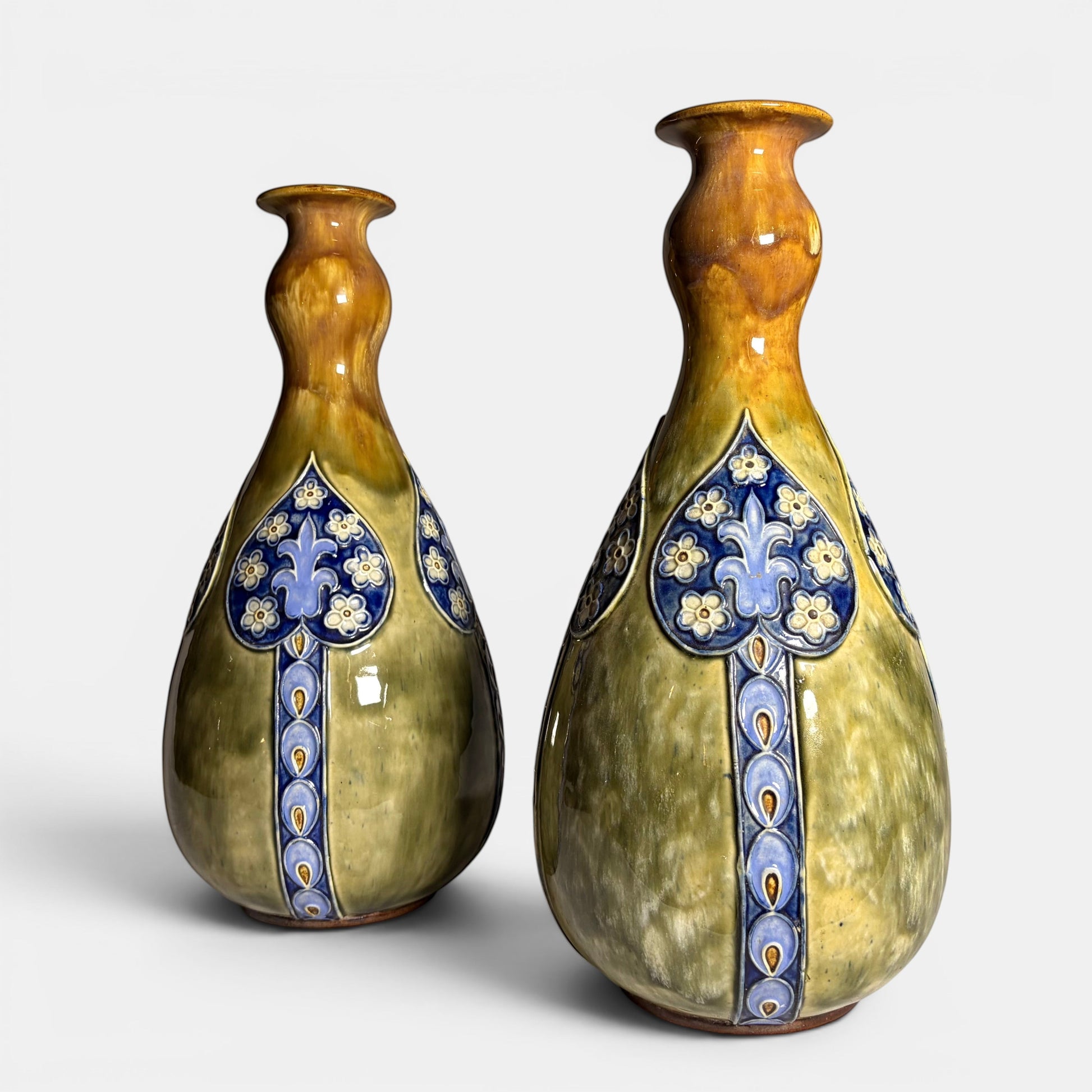 KLS Vaults pair of olive-green and amber glazed stoneware bottle vases with blue floral relief detail, Burslem, England, c.1901-1922.