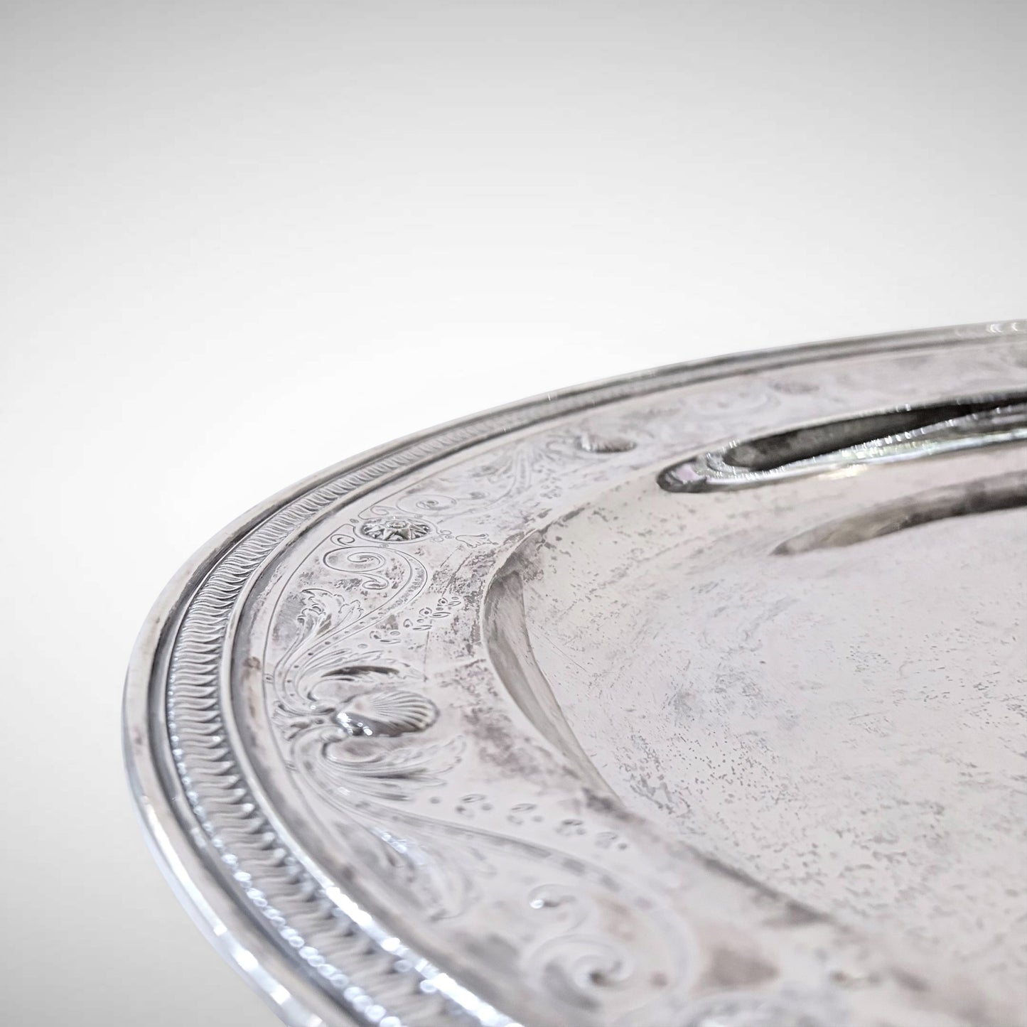 KLS Vaults large 1917 Tiffany & Co. sterling silver platter featuring intricate foliate engraving and shell borders.