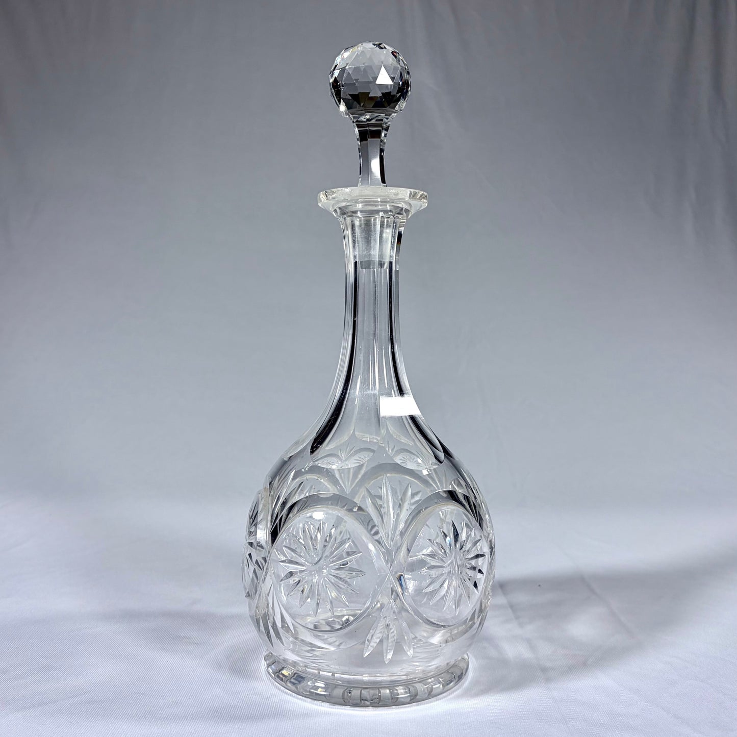 KLS Vaults late Victorian cut crystal spirit decanter with starburst motifs and a faceted spherical stopper.
