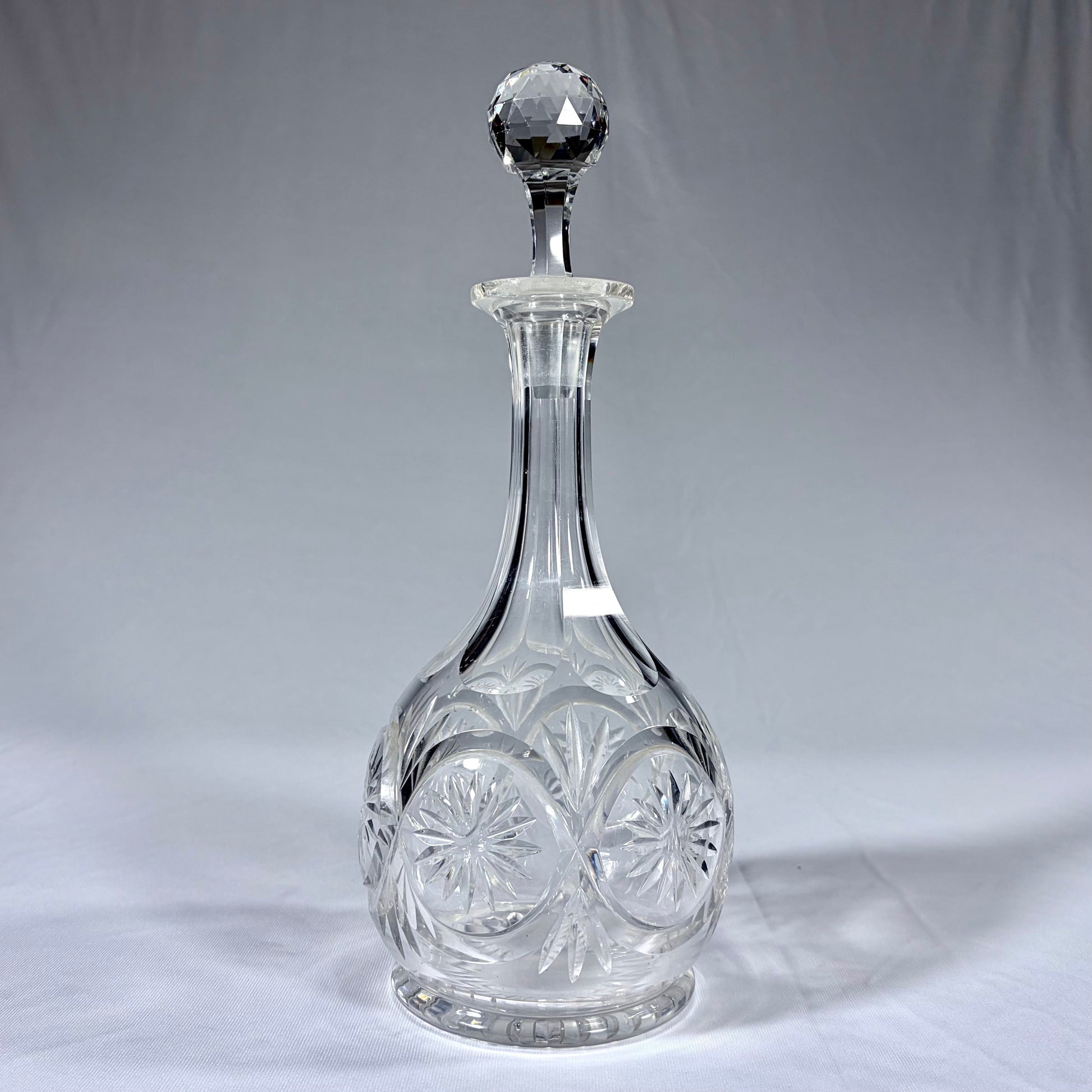 KLS Vaults late Victorian cut crystal spirit decanter with starburst motifs and a faceted spherical stopper.