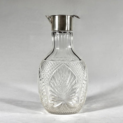 KLS Vaults Victorian claret jug with diamond-cut crystal body and sterling silver hinged lid and pouring spout.